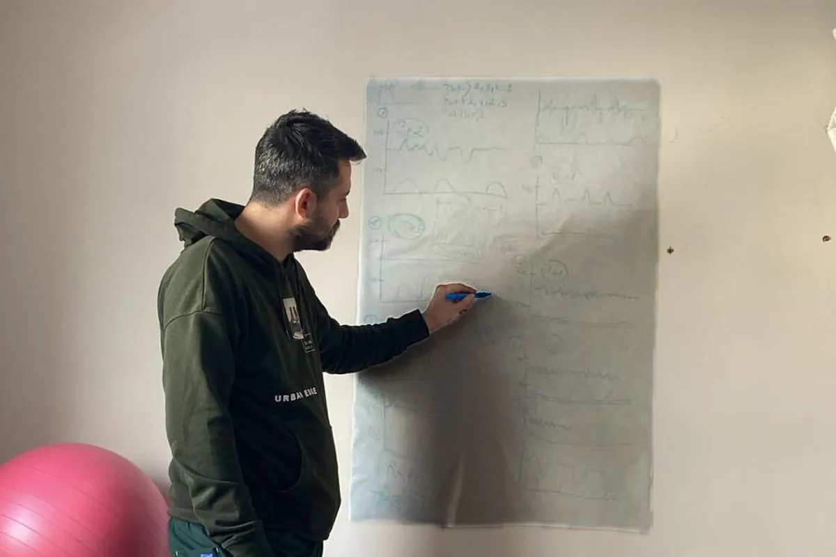 Op. Dr. Hüseyin Efe Akalın explaining pregnancy follow-up on a wall chart