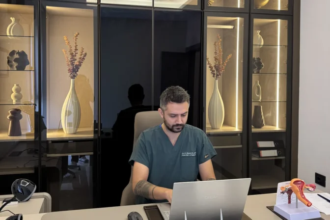 Op. Dr. Hüseyin Efe Akalın at his desk with a uterus model on it