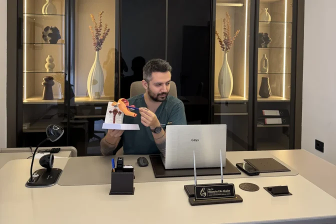 Op. Dr. Hüseyin Efe Akalın holding a uterus model while explaining